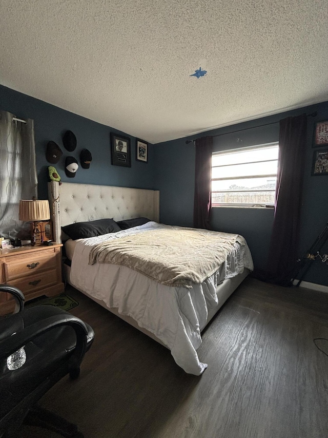 bedroom featuring dark hardwood / wood-style flooring and a textured ceiling