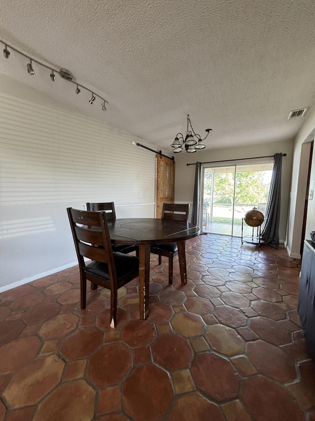 dining room featuring a barn door and a textured ceiling