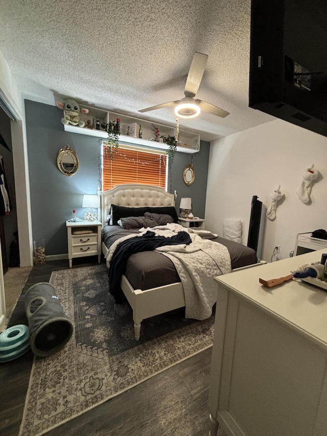 bedroom featuring ceiling fan, dark hardwood / wood-style flooring, and a textured ceiling