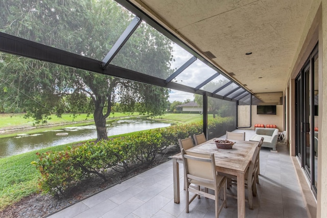 view of patio / terrace with a lanai and a water view