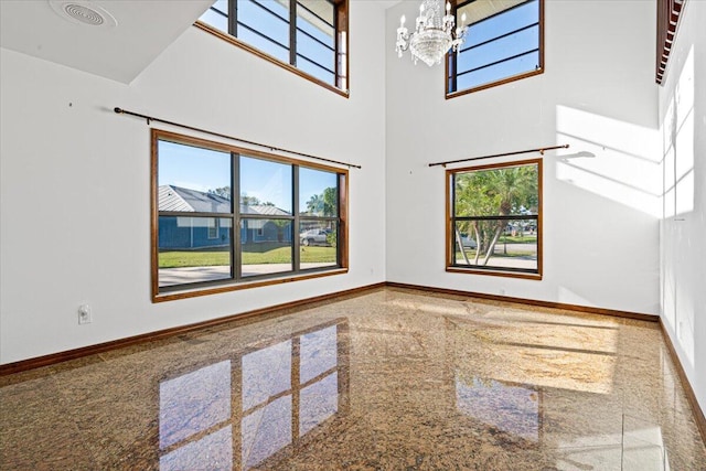 unfurnished room with a chandelier and a high ceiling