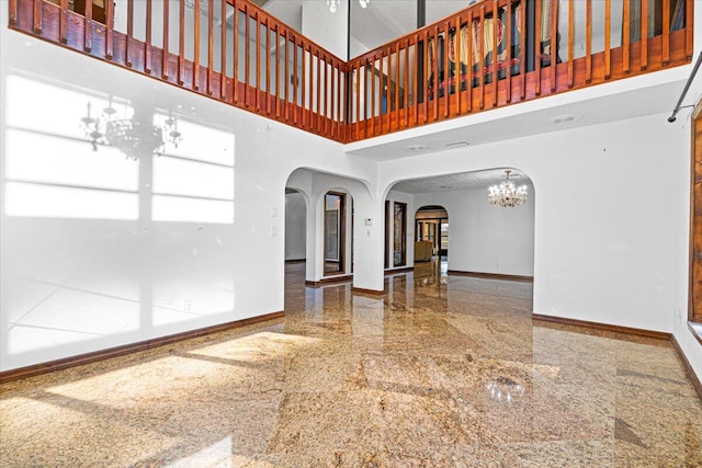 empty room featuring a high ceiling and a notable chandelier