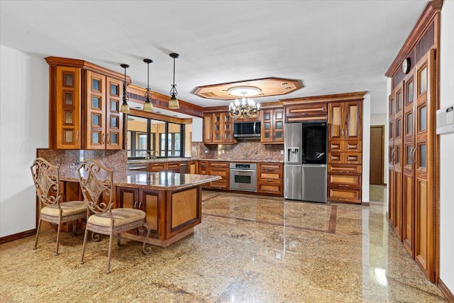 kitchen with backsplash, decorative light fixtures, appliances with stainless steel finishes, a notable chandelier, and kitchen peninsula