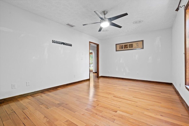 unfurnished room with a textured ceiling, light hardwood / wood-style floors, and ceiling fan