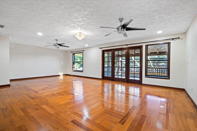 unfurnished room with light wood-type flooring, a textured ceiling, and ceiling fan