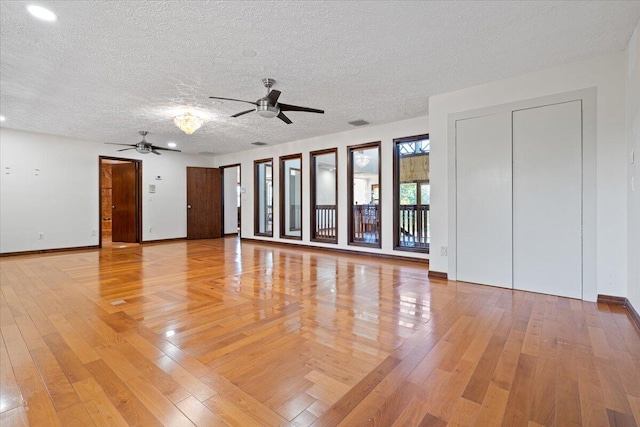 unfurnished living room with hardwood / wood-style flooring, ceiling fan, and a textured ceiling