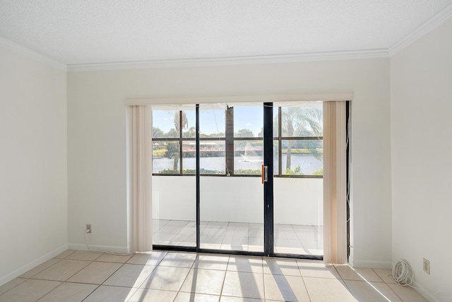 empty room featuring a healthy amount of sunlight, a water view, crown molding, and light tile patterned flooring