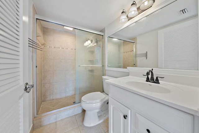 bathroom featuring tile patterned flooring, vanity, a shower with shower door, and toilet