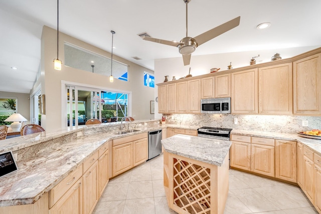 kitchen with appliances with stainless steel finishes, vaulted ceiling, ceiling fan, sink, and pendant lighting