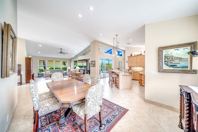 dining area with ceiling fan, plenty of natural light, light tile patterned floors, and vaulted ceiling