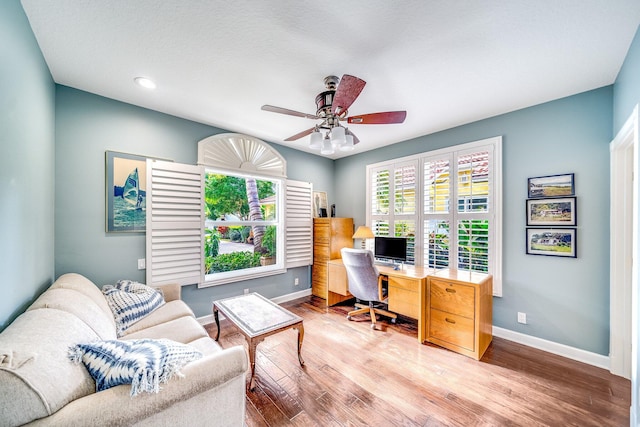 office area with light hardwood / wood-style flooring and ceiling fan