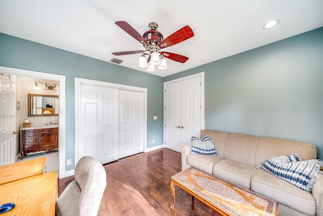 living room featuring ceiling fan, wood-type flooring, and sink