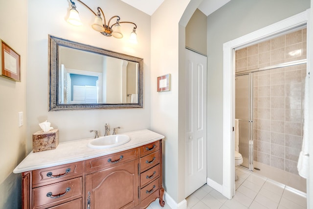 bathroom with tile patterned floors, vanity, a shower with shower door, and toilet