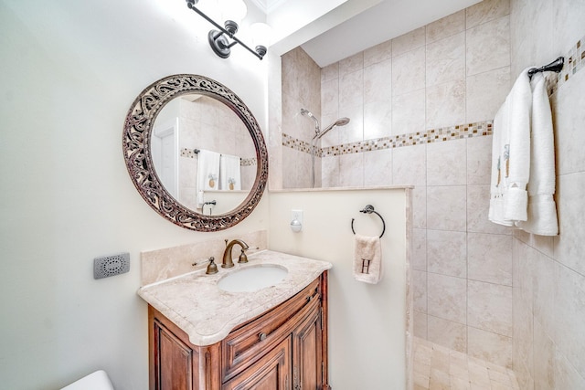 bathroom featuring a tile shower and vanity