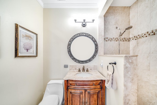 bathroom featuring vanity, toilet, ornamental molding, and tiled shower