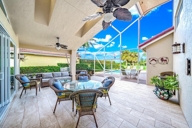 view of patio / terrace featuring outdoor lounge area, glass enclosure, and ceiling fan