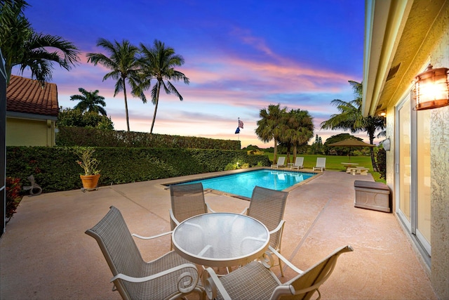 pool at dusk with a patio