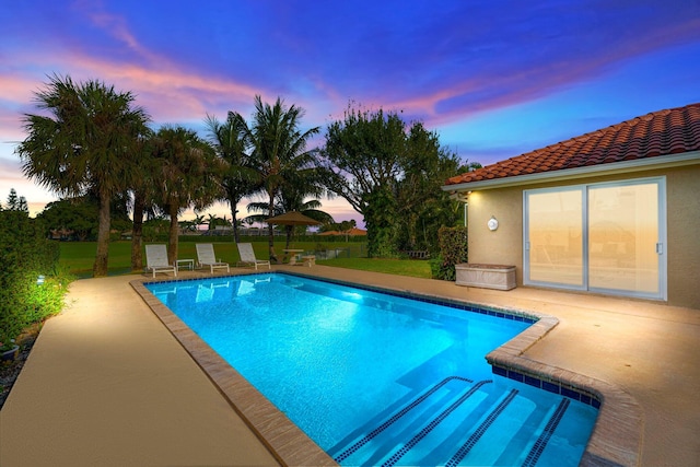 pool at dusk with a patio