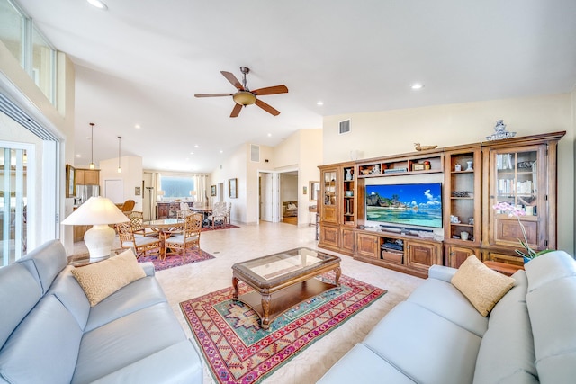 tiled living room with ceiling fan and high vaulted ceiling