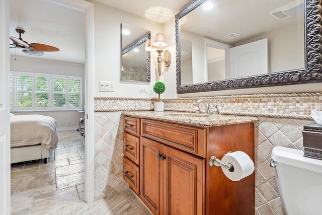 bathroom with ceiling fan, vanity, ornamental molding, and toilet