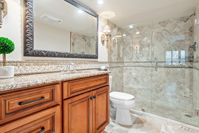 bathroom featuring vanity, toilet, a shower with door, and tile walls