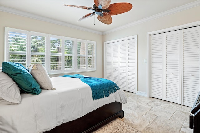 bedroom with ceiling fan, ornamental molding, and two closets