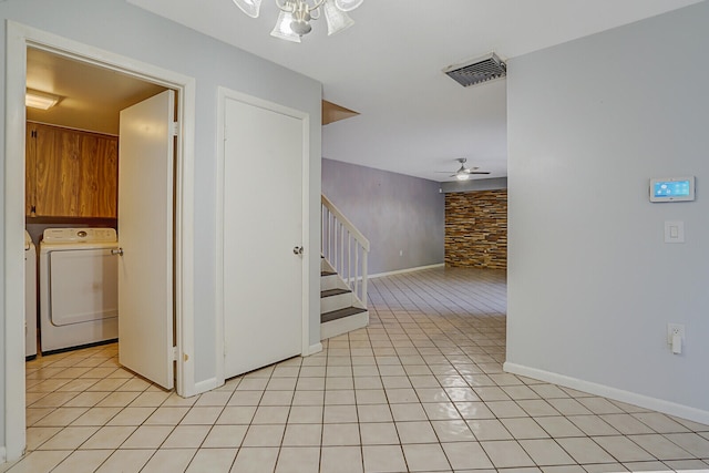 corridor with light tile patterned flooring and independent washer and dryer