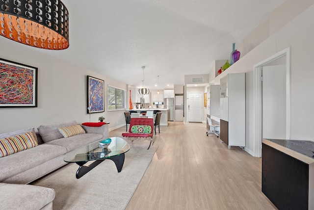 living room featuring a chandelier and light hardwood / wood-style flooring