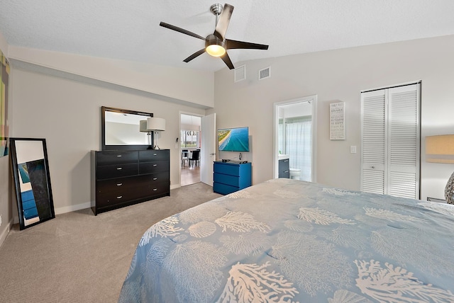 bedroom featuring ceiling fan, ensuite bath, light carpet, and vaulted ceiling