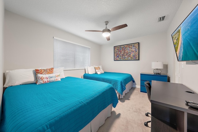 bedroom featuring a textured ceiling, ceiling fan, and light carpet