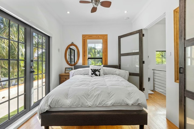 bedroom with ceiling fan, light hardwood / wood-style floors, and multiple windows