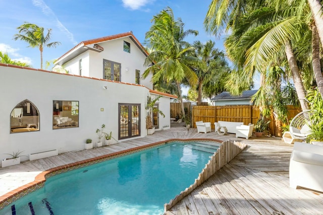 view of swimming pool with a wooden deck and french doors