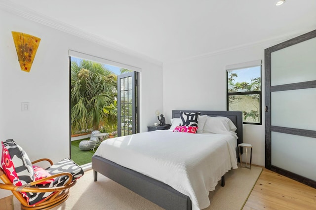 bedroom featuring light hardwood / wood-style floors, multiple windows, and ornamental molding