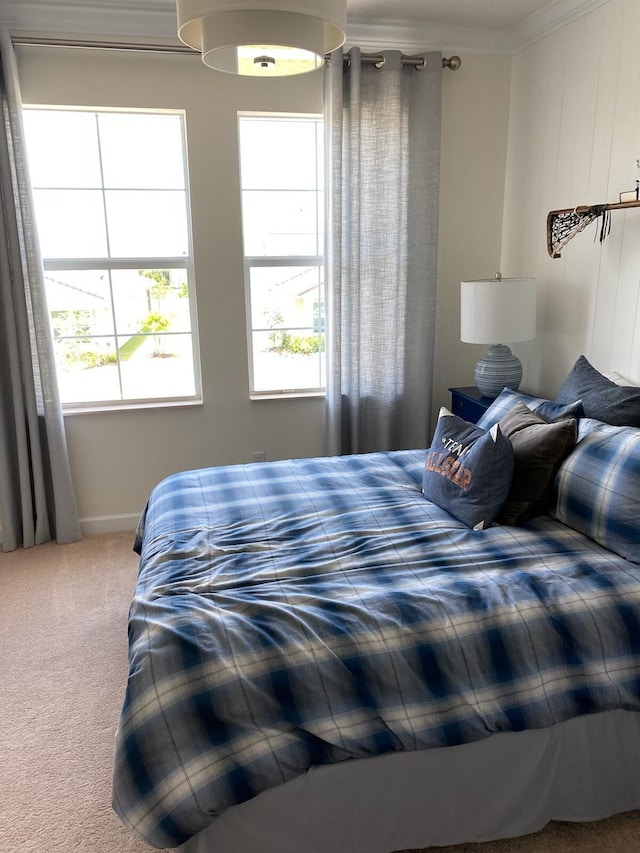 carpeted bedroom with multiple windows and ornamental molding