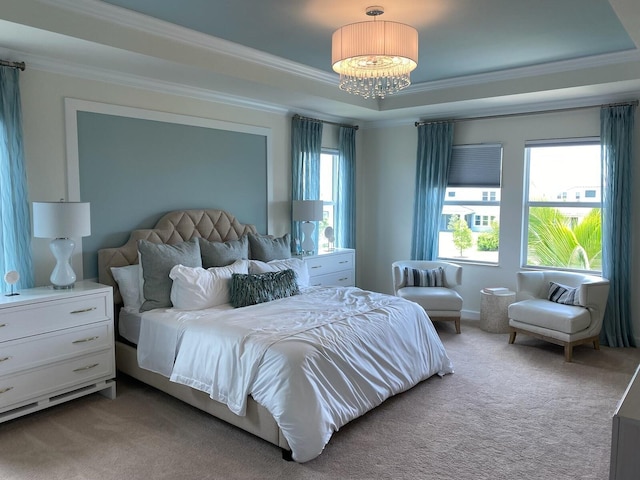 carpeted bedroom featuring a raised ceiling, crown molding, and a chandelier