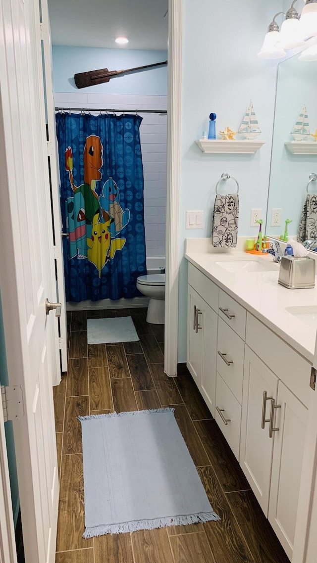 full bathroom featuring vanity, hardwood / wood-style flooring, toilet, and shower / tub combo with curtain