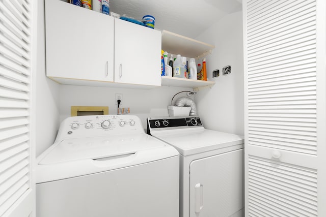 laundry room with washer and dryer and cabinets