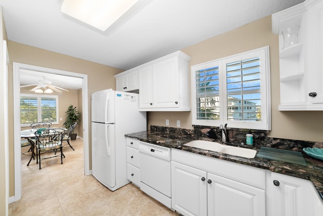 kitchen with white appliances, white cabinetry, dark stone countertops, and sink