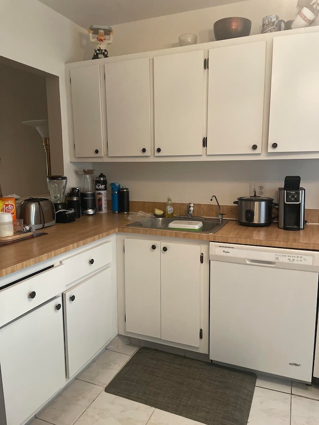 kitchen with white cabinets, sink, and white dishwasher