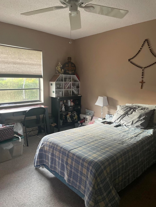 bedroom with carpet, a textured ceiling, and ceiling fan