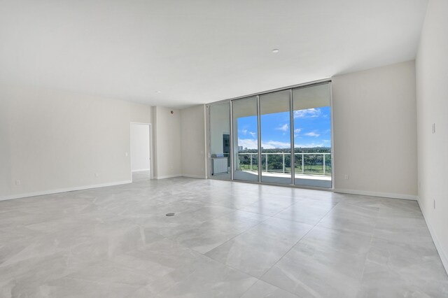 empty room with expansive windows and baseboards