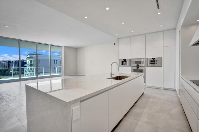 kitchen featuring modern cabinets, custom exhaust hood, white cabinets, and stainless steel double oven