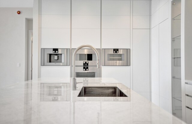 kitchen featuring premium range hood, modern cabinets, black electric cooktop, and light countertops