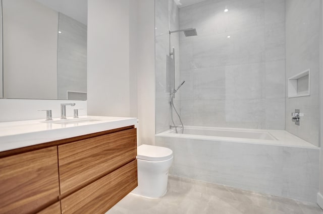 bathroom with tiled shower / bath, vanity, and toilet