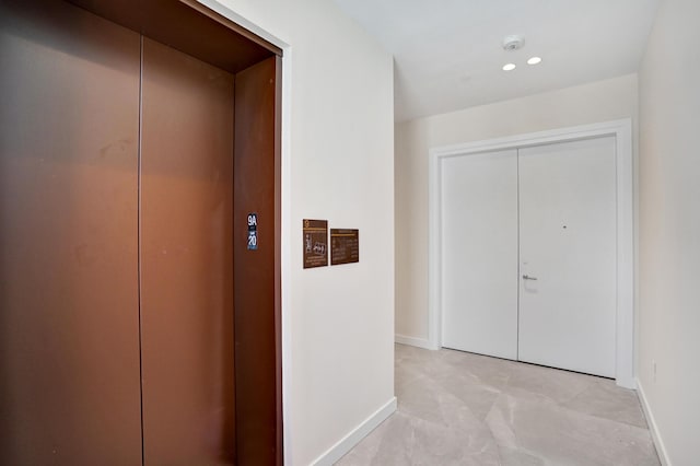 hallway with elevator, baseboards, and recessed lighting