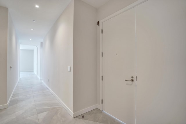 hall with baseboards and recessed lighting