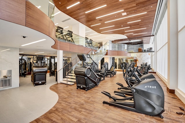 exercise room with wooden ceiling, wood finished floors, and visible vents