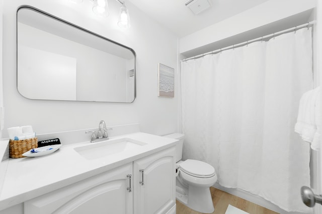 bathroom featuring hardwood / wood-style flooring, vanity, and toilet