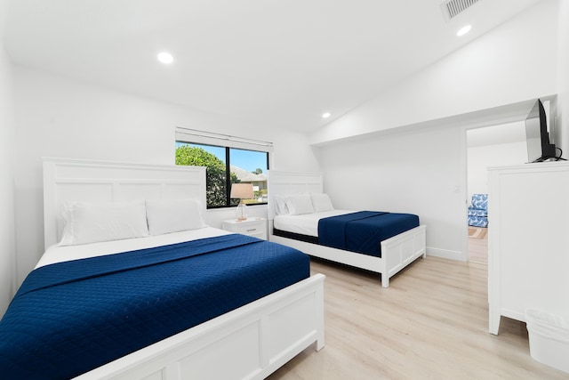 bedroom featuring lofted ceiling and light wood-type flooring