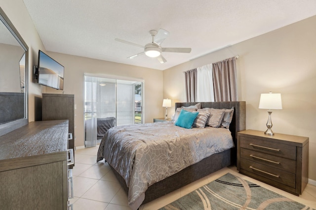 tiled bedroom with ceiling fan and a textured ceiling